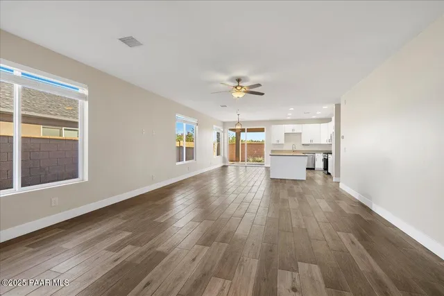 a view of a livingroom with wooden floor and a kitchen