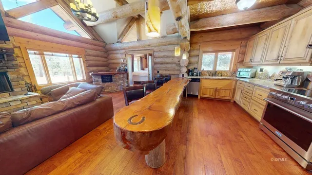 a large room with wooden floor pool table and chairs