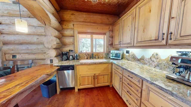 a kitchen with stainless steel appliances granite countertop wooden cabinets a sink and dishwasher a stove with wooden floor