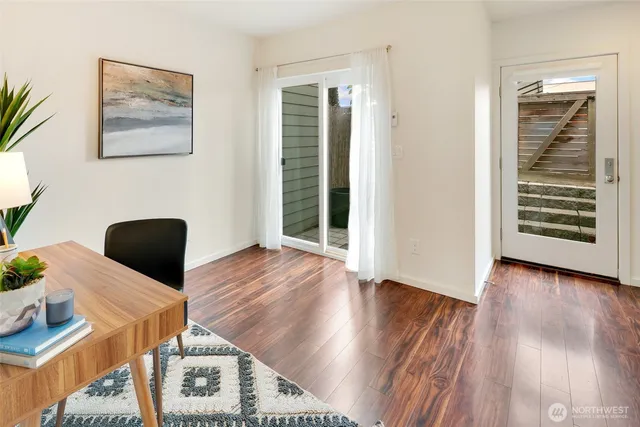 a view of a hallway with wooden floor and a workspace