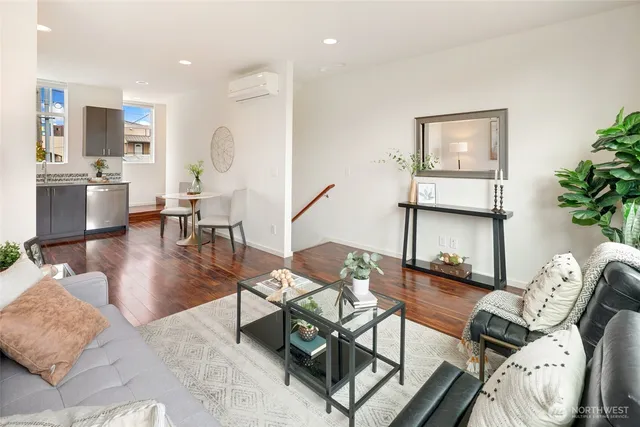 a living room with furniture a wooden floor and a potted plant