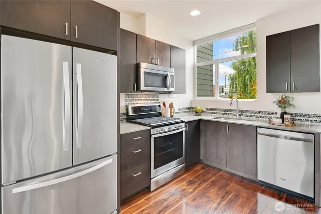 a kitchen with granite countertop a refrigerator stove top oven and sink
