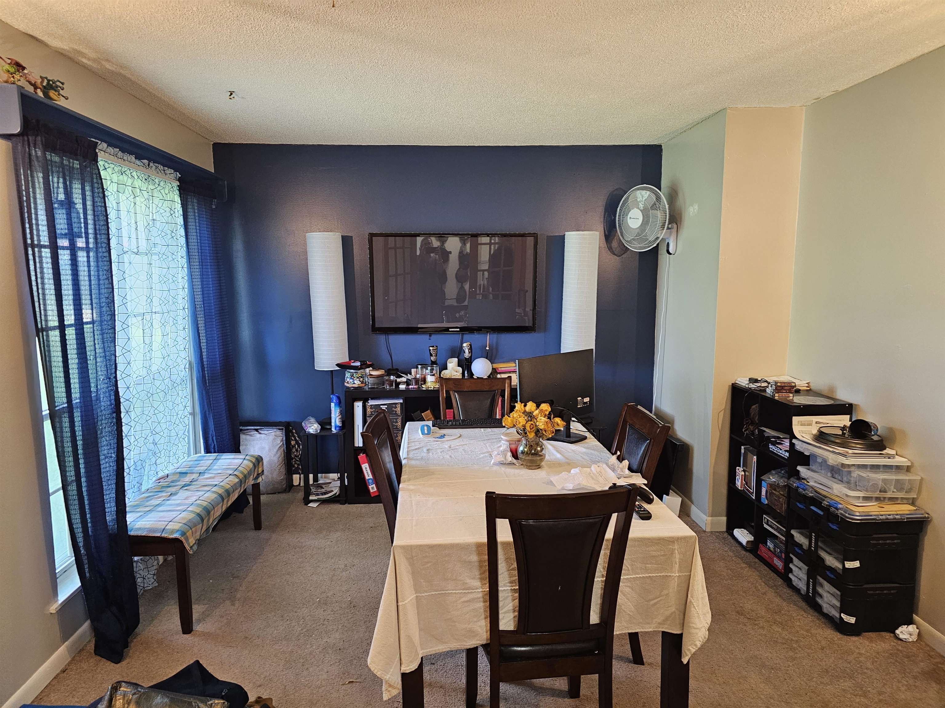 Carpeted dining space with a textured ceiling and baseboards