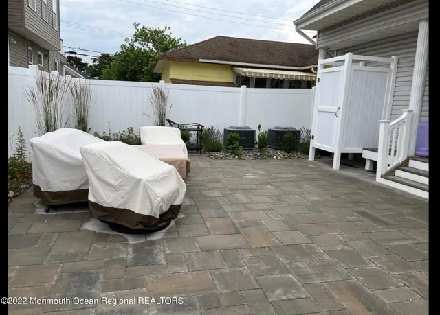 a view of a patio with table and chairs with wooden fence