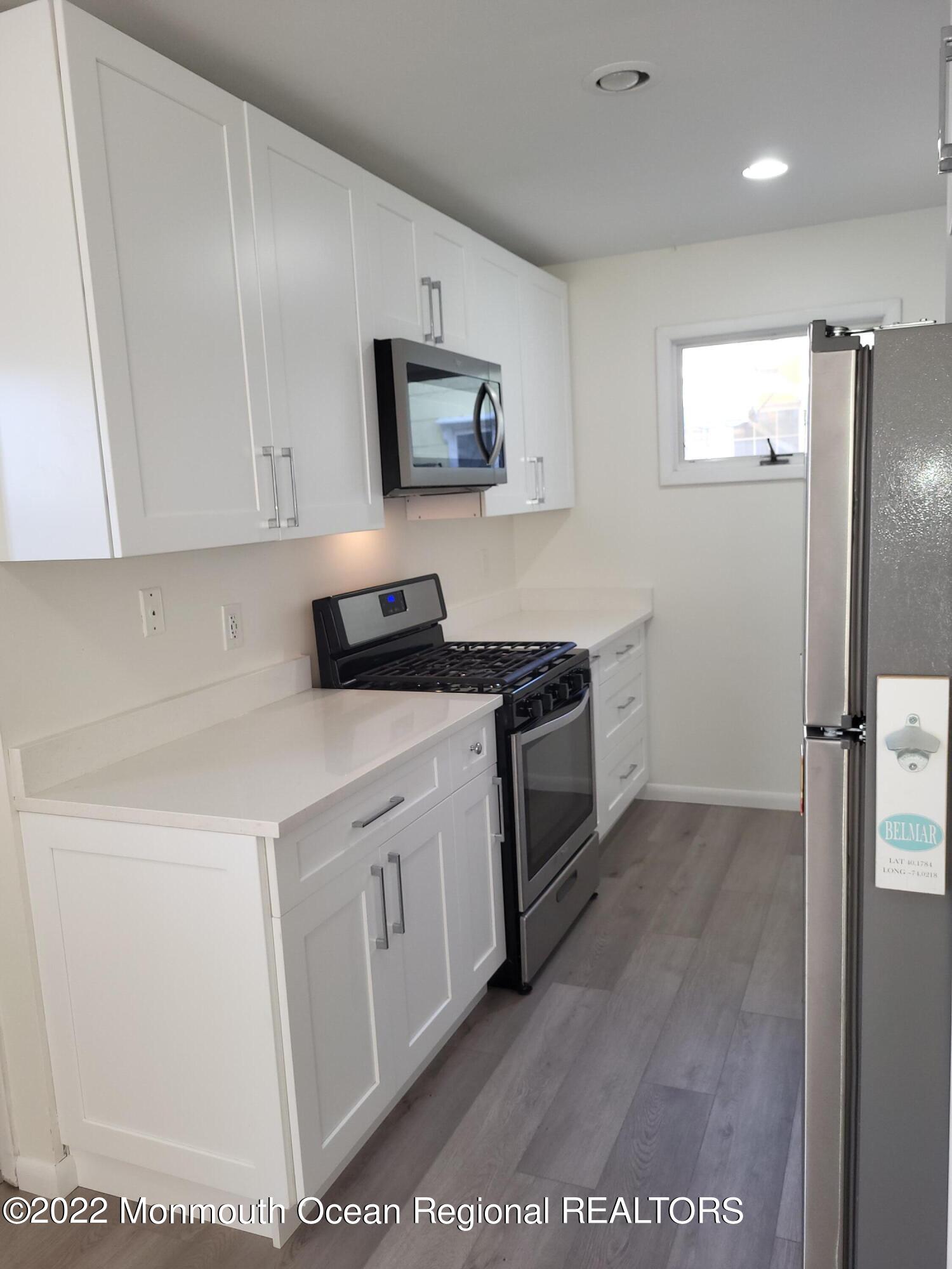 1703 A Street, Unit REAR Belmar, NJ 07719 - Photo 8 of 29 a kitchen with stainless steel appliances white cabinets and a refrigerator