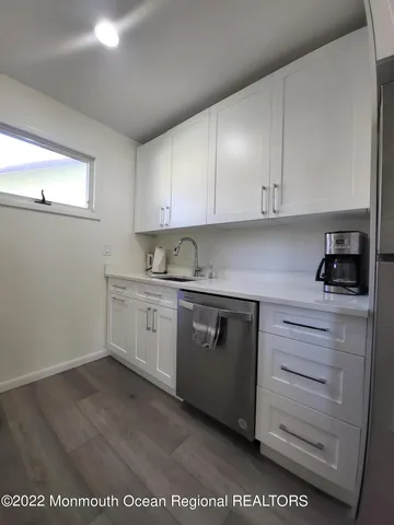 a kitchen with granite countertop white cabinets and white appliances