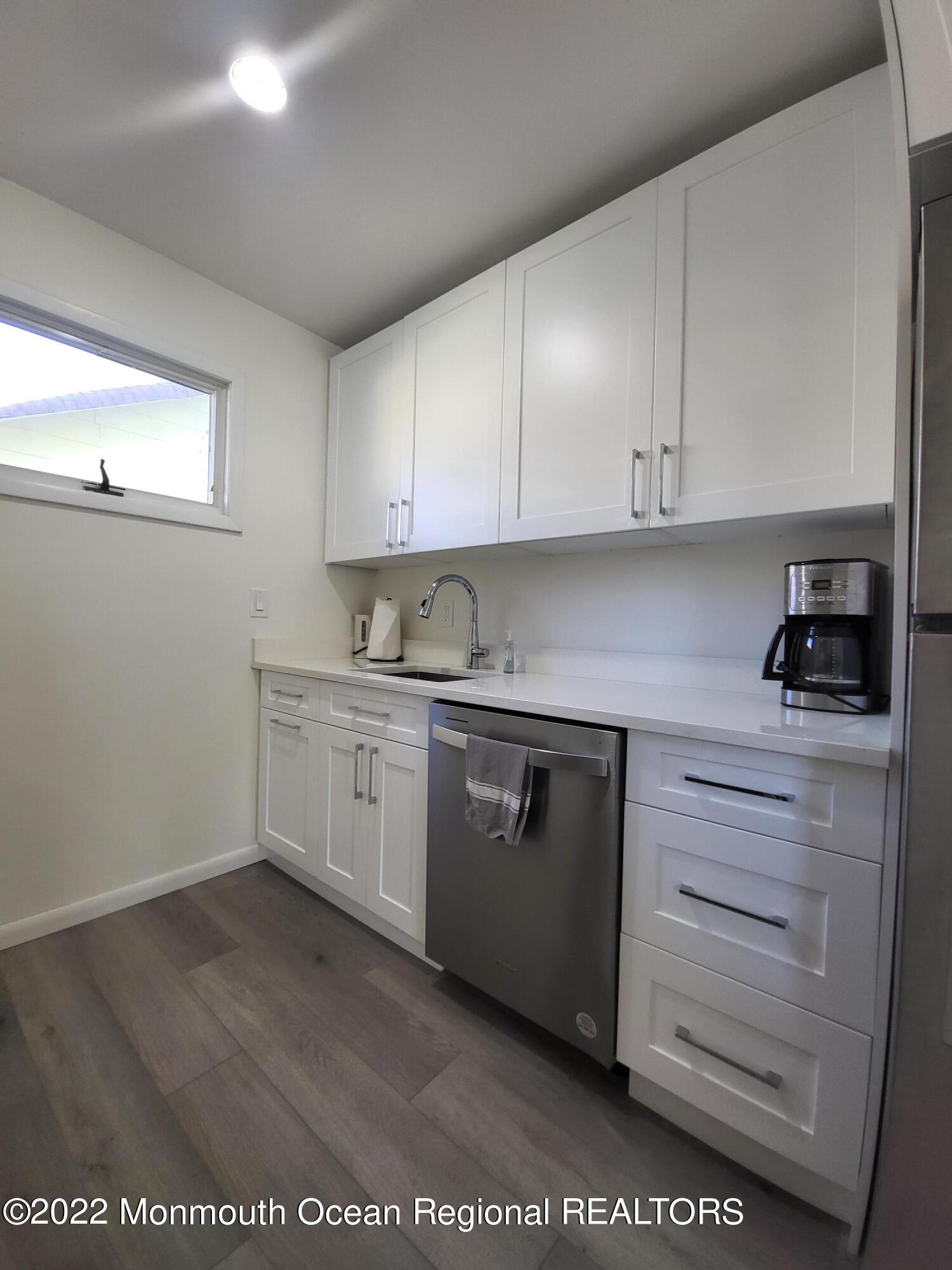 1703 A Street, Unit REAR Belmar, NJ 07719 - Photo 9 of 29 a kitchen with granite countertop white cabinets and white appliances
