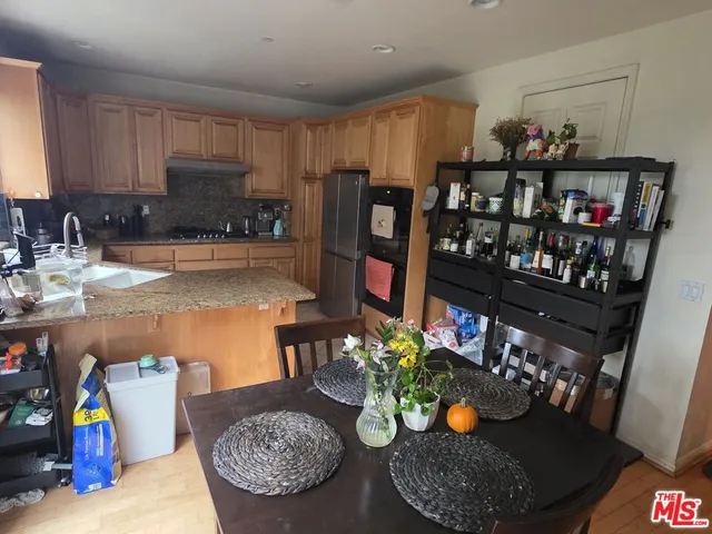 a kitchen with stainless steel appliances granite countertop a sink refrigerator and a stove