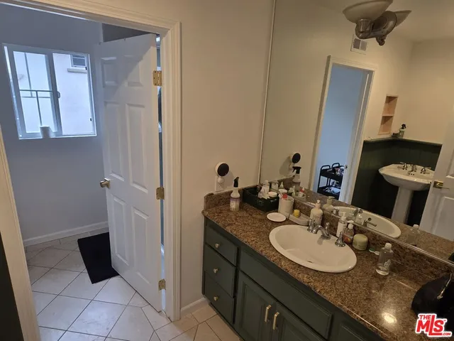 a bathroom with a granite countertop sink and a mirror