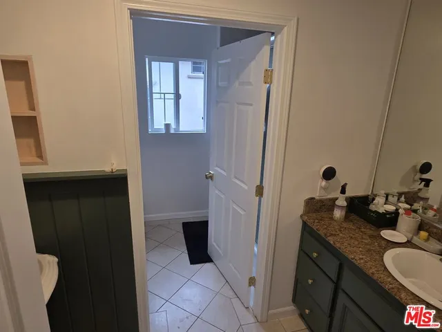 a bathroom with a granite countertop sink and a mirror