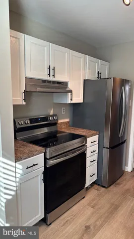 a kitchen with stainless steel appliances a stove a refrigerator and cabinets