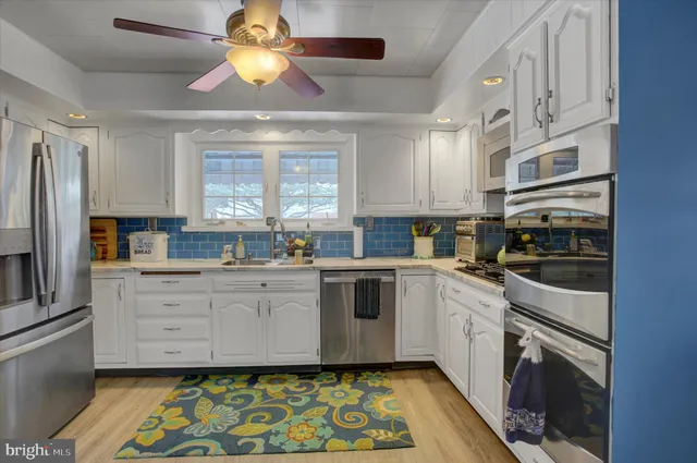 a kitchen with stainless steel appliances granite countertop a stove a sink and a microwave