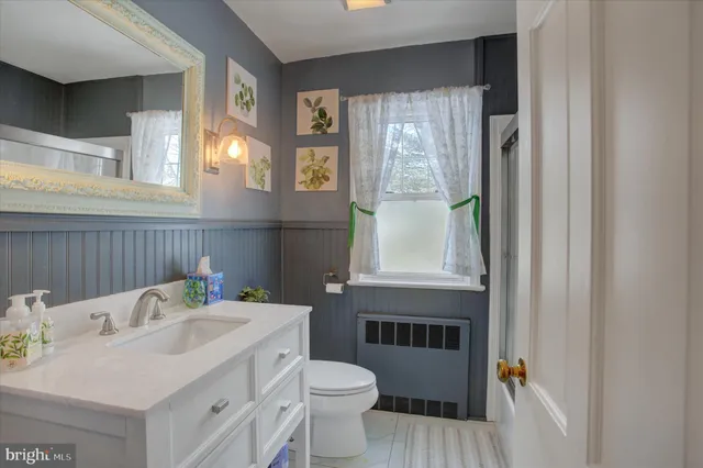 a bathroom with a window sink and mirror