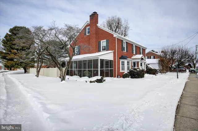 a front view of a house with a yard covered in snow