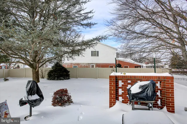 a view of a white house with a large trees