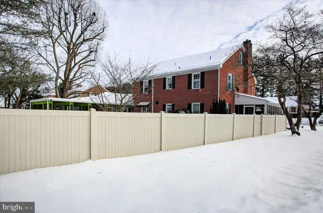 a front view of a house with a yard covered in snow