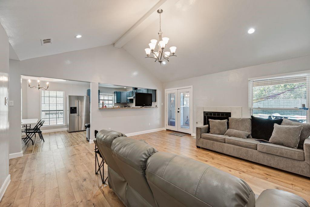5114 Ben Davis Road Sachse, TX 75048 - Photo 9 of 28 Spacious living area featuring vaulted ceilings, wood-finish flooring, recessed lighting, and a chandelier