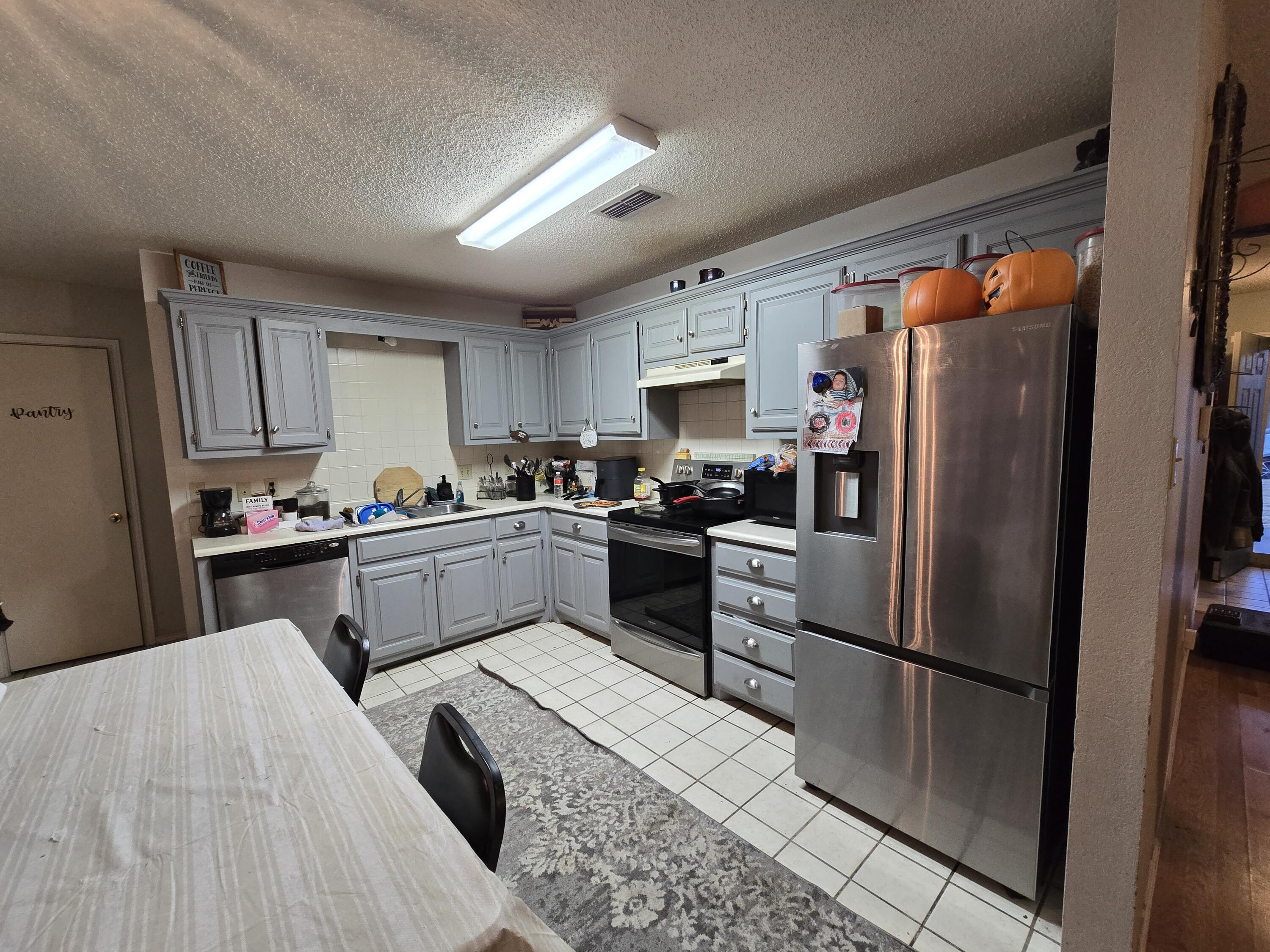 5806 12th Street Lubbock, TX 79416 - Photo 5 of 17 a kitchen with stainless steel appliances a refrigerator sink and cabinets