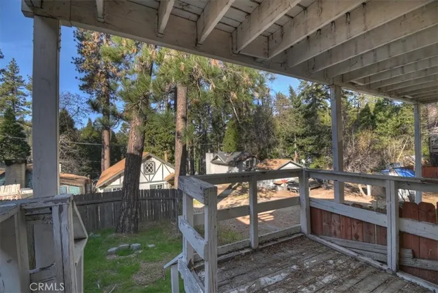 a view of a porch with chairs and wooden fence