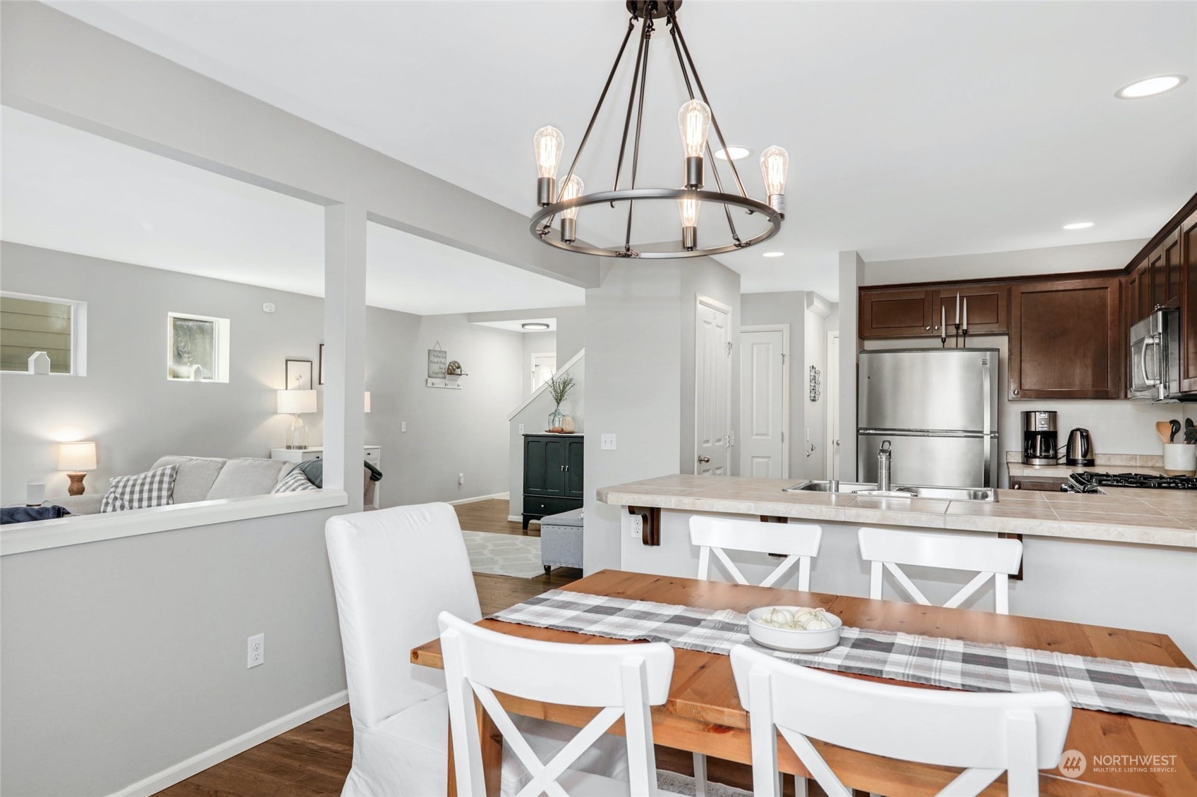 15 194th Street Southwest Bothell, WA 98012 - Photo 14 of 27 a kitchen with stainless steel appliances kitchen island granite countertop a dining table chairs and white cabinets