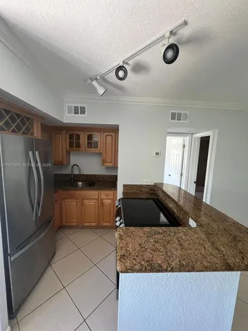 a kitchen with a sink a refrigerator and cabinets