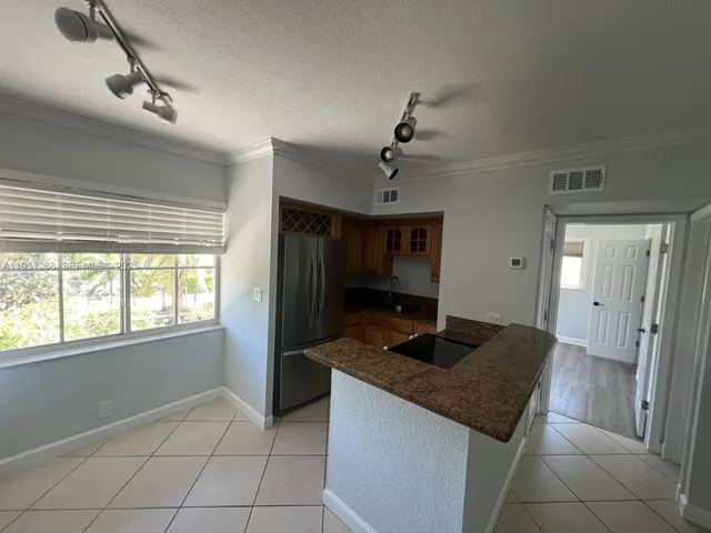 a kitchen with granite countertop a sink and a refrigerator