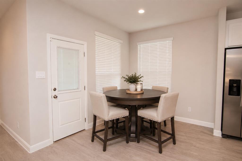 1804 Mensa Drive Haslet, TX 76052 - Photo 8 of 30 Kitchen featuring stainless steel refrigerator, white cabinetry, recessed lighting, wood-finish flooring, and a white paneled door with frosted glass