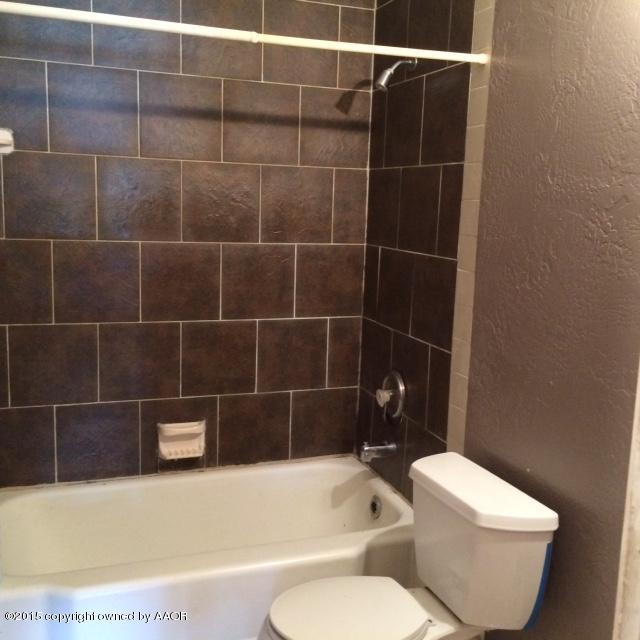 3704 South Harrison Street Amarillo, TX 79110 - Photo 9 of 13 a bathroom with a toilet and bathtub