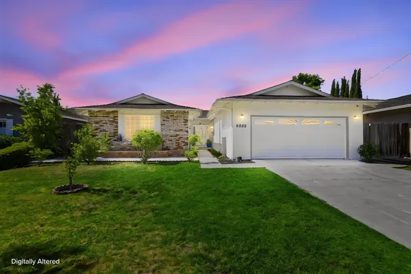 a front view of a house with a garden and yard