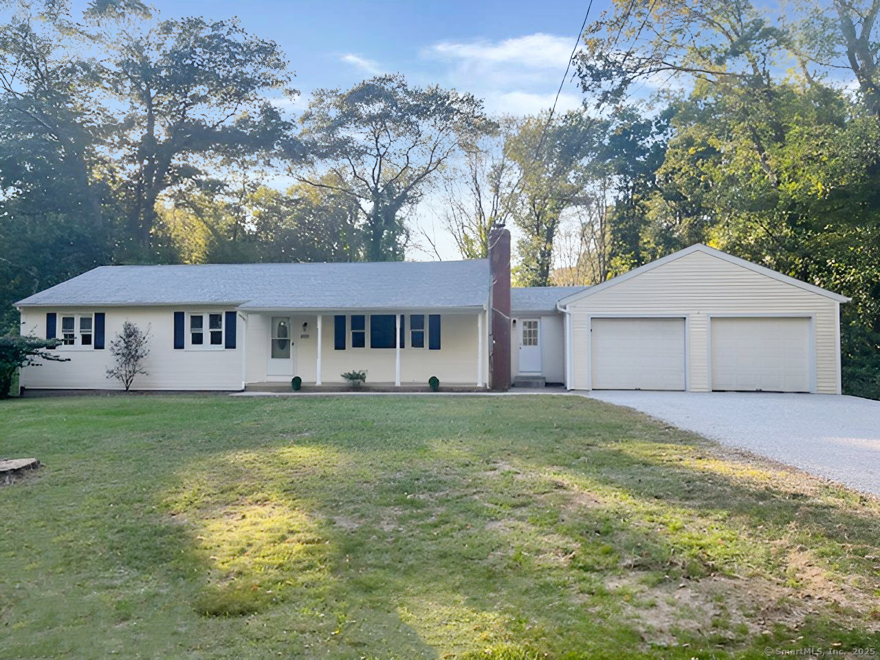 a front view of a house with a garden and trees