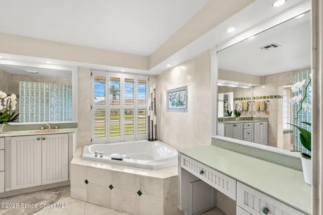 a bathroom with a granite countertop sink and a large mirror