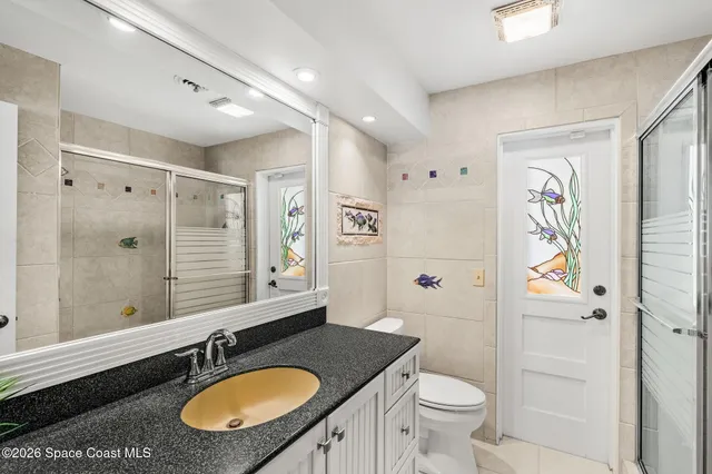 a bathroom with a granite countertop sink toilet a mirror and shower