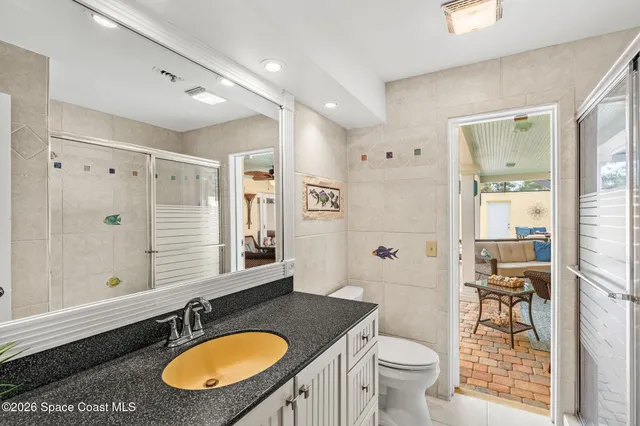 a bathroom with a granite countertop sink toilet a mirror and shower