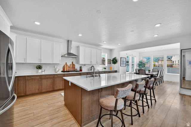 1165 West Union Bench Drive Mapleton, UT 84664 - Photo 13 of 61 Spacious kitchen featuring an expansive central island with a light-toned countertop, two-tone cabinetry, stainless steel appliances, wood-finish flooring, and recessed lighting