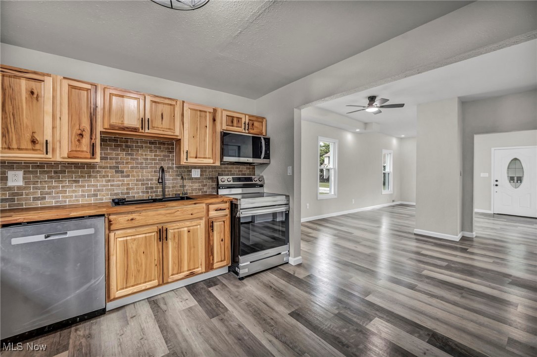 397 Furnace Road Conneaut, OH 44030 - Photo 10 of 36 Kitchen featuring appliances with stainless steel finishes, wooden counters, tasteful backsplash, dark wood-type flooring, and a ceiling fan