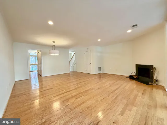 a view of empty room with wooden floor and fireplace