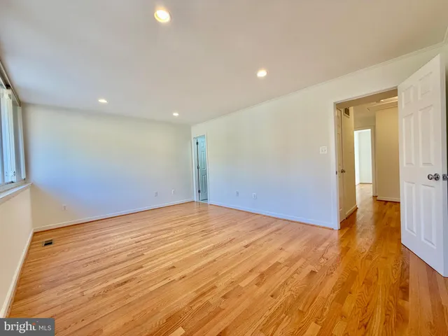 a view of empty room with wooden floor