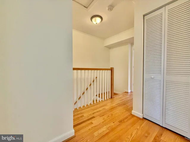 a view of a hallway with wooden floor and a window