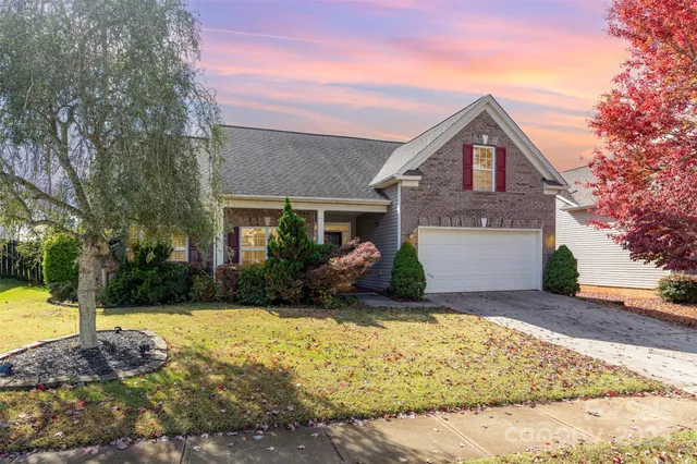 a front view of a house with a yard and trees