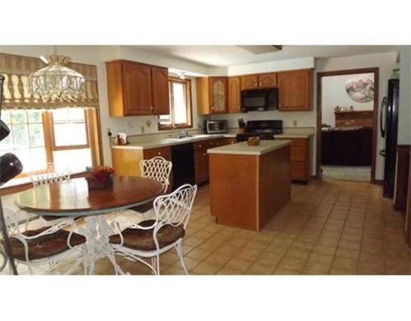 1 Michigan Road Tyngsborough, MA 01879 - Photo 3 of 9 a kitchen with granite countertop a stove a sink a dining table and chairs