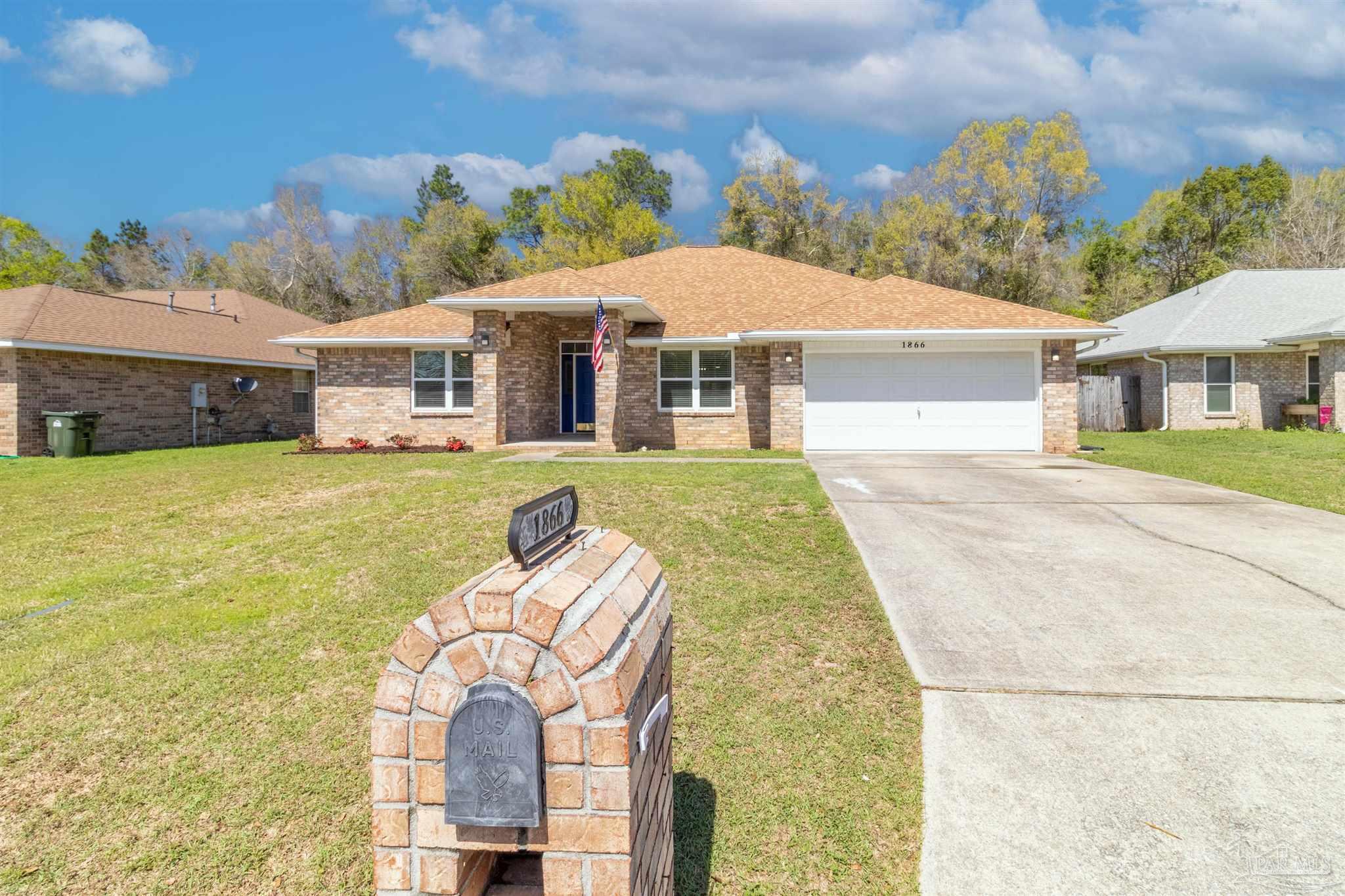 a front view of a house with a garden and yard