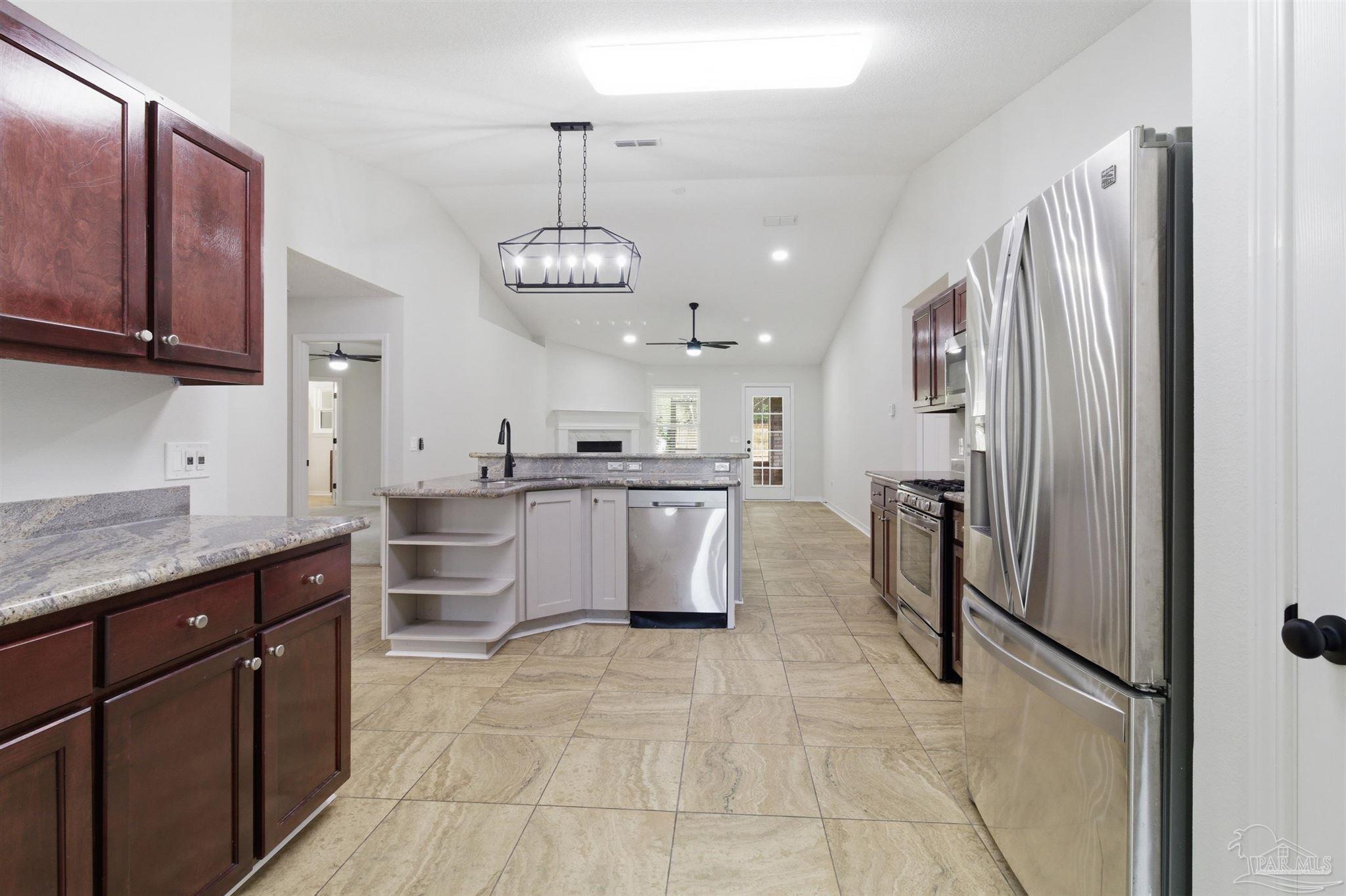 1866 Wareham Way Cantonment, FL 32533 - Photo 4 of 33 a kitchen with stainless steel appliances granite countertop a refrigerator a sink dishwasher a stove and a sink with wooden floor
