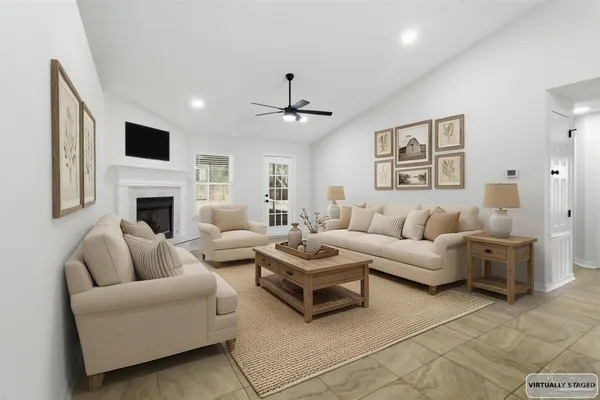 a living room with furniture a flat screen tv and a fireplace