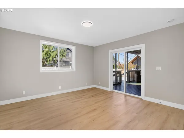a view of empty room with wooden floor and window