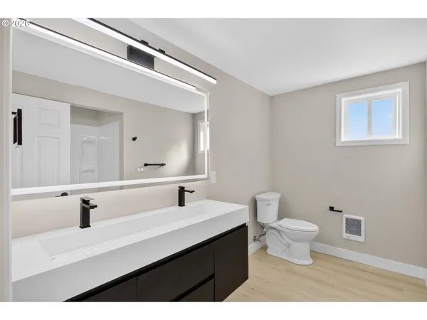 a bathroom with a sink toilet a mirror and vanity