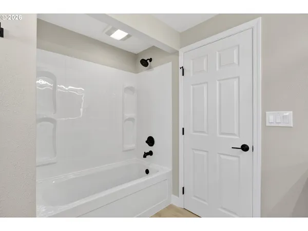 a bathroom with a bathtub shower and toilet