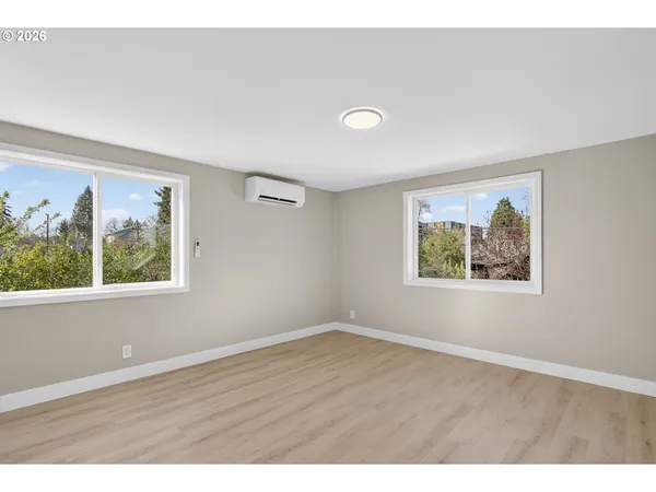 an empty room with wooden floor and window