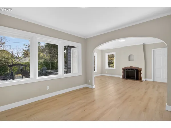 a view of empty room with wooden floor and fireplace