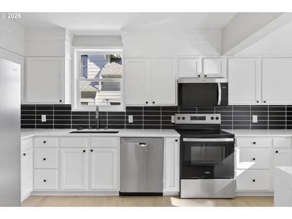 a kitchen with stainless steel appliances a stove a microwave sink and cabinets