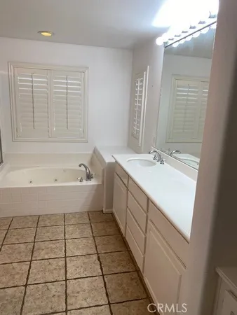 a spacious bathroom with a bathtub sink and mirror
